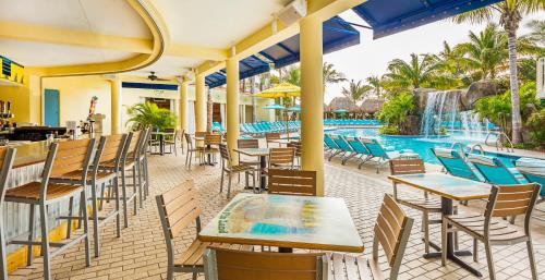 a restaurant with tables and chairs and a swimming pool at Margaritaville Hollywood Beach Resort in Hollywood