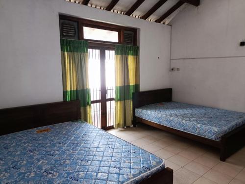 a room with two beds and a window at LP Residence in Pannipitiya