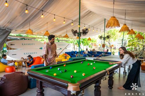 a man and a woman playing pool in a tent at Zostel Kochi, Kumbalangi in Cochin