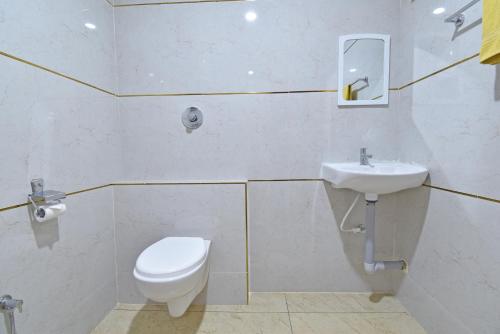 a bathroom with a toilet and a sink at Hotel De Lux Splendid in Pondicherry