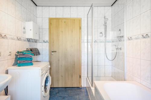 a bathroom with a washing machine and a shower at Altvogtshof in Furtwangen