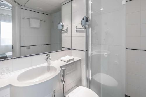a bathroom with a toilet and a sink and a shower at Scandic Espoo in Espoo