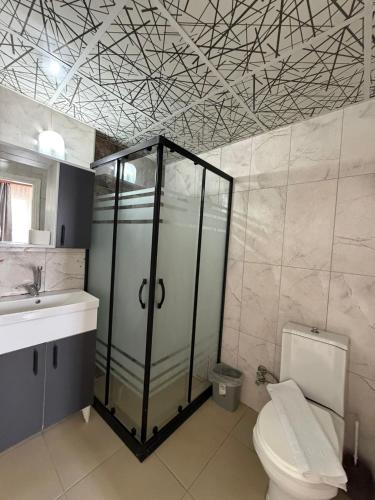 a bathroom with a shower and a toilet and a sink at Rosella Hotel in Alanya