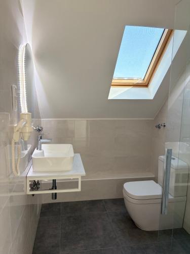 a bathroom with a skylight and a toilet and a sink at Ady80 in Balatonmáriafürdő