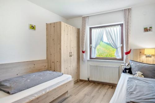 a bedroom with two beds and a window at Altvogtshof in Furtwangen