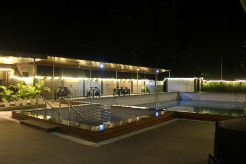 a swimming pool at night with horses in the background at Peridott Inn in Jaigaon