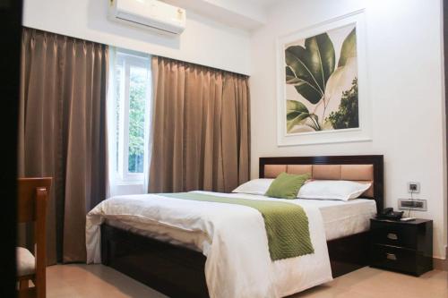a bedroom with a large bed and a window at Peridott Inn in Jaigaon
