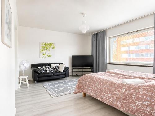 a bedroom with a bed and a couch at Aava's apt. FREE Parking in Pori