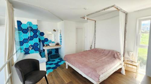 a bedroom with a canopy bed and a chair at Blue Marine in Kalogrea