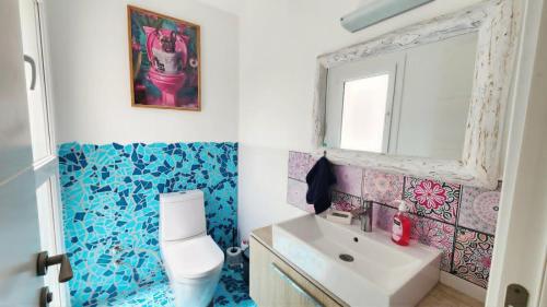 a bathroom with a white toilet and a sink at Blue Marine in Kalogrea