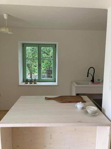 a kitchen with a table and a sink and a window at Ubytování NAPOLI in Stará Červená Voda