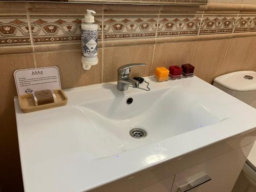a white sink in a bathroom with a toilet at Alojamentos Vila Alpalhão in Alpalhão