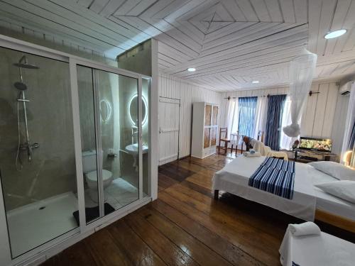 a bedroom with a shower and a bed and a bathroom at Hostel Sao Gabriel - new pool in São Tomé