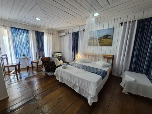 a bedroom with a bed and a table and chairs at Hostel Sao Gabriel - new pool in São Tomé