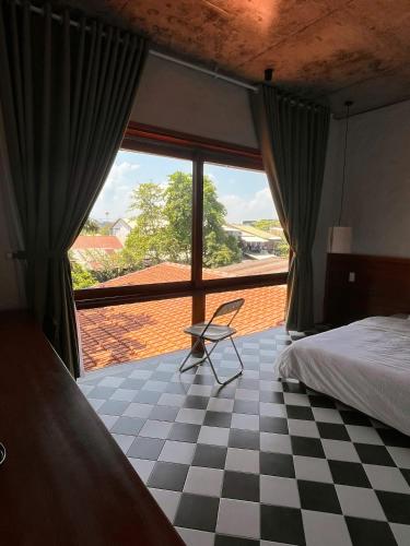 a bedroom with a bed and a large window at Berry Boutique in Hue