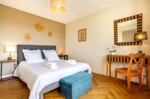 a bedroom with a bed and a desk and a mirror at L'escale bleue in Plomeur