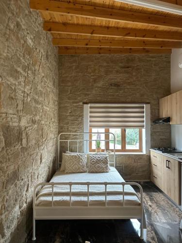 ein Schlafzimmer mit einem Bett in einer Steinwand in der Unterkunft Stone Nest in Tochni
