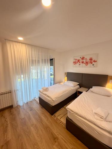 a hotel room with two beds and a window at Domus Klek in Kučinić-Selo