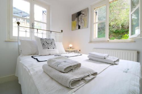 a bedroom with a white bed with towels on it at Guesthouse Thomas in Vátos