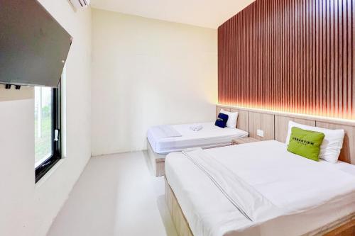 a small room with two beds and a window at Urbanview Hotel MD Residence in Sunggal