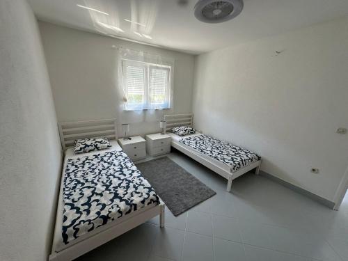 two beds sitting in a room with a window at Panorama in Drvenik Veli