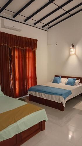a bedroom with two beds and a window at Ariyana Sky Suites in Matara
