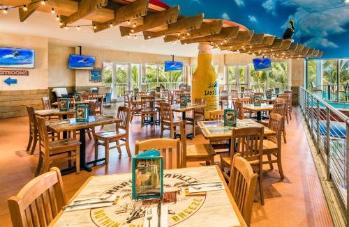 a restaurant with wooden tables and chairs and windows at Margaritaville Hollywood Beach Resort in Hollywood