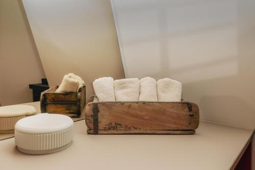 a bathroom with towels in a wooden box on a counter at HOY bamberg boutique hotel in Bamberg