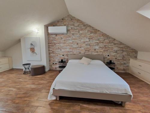 a bedroom with a large bed and a brick wall at Riflessi sul lago Lierna bed and breakfast in Lierna