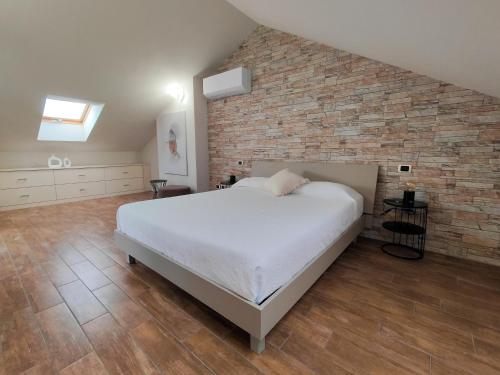 a bedroom with a bed and a brick wall at Riflessi sul lago Lierna bed and breakfast in Lierna