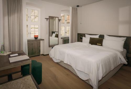a bedroom with a large white bed and a mirror at HOY bamberg boutique hotel in Bamberg