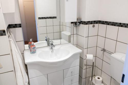 a white bathroom with a sink and a shower at Strandnahe Ferienwohnung mit Privatweg, Spielplatz & Aufzug in Sankt Peter-Ording