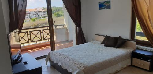 a bedroom with a bed and a large window at Oasis Resort&Spa Lozenets Studio 12 in Lozenets