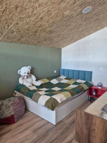 a teddy bear sitting on a bed in a room at Lukas cottage in sagarejo in Sagarejo