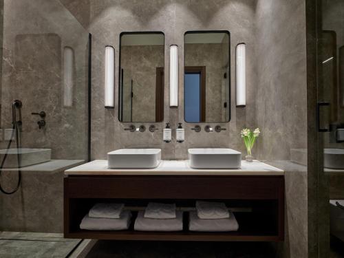 ein Badezimmer mit zwei Waschbecken und zwei Spiegeln in der Unterkunft ON Residence - Small Luxury Hotels of the World in Thessaloniki