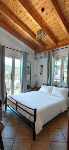 a bedroom with a large bed with a wooden ceiling at Sea & Sun Ikaria in Gialiskari