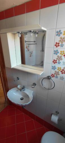 a bathroom with a sink and a mirror and a toilet at Sea & Sun Ikaria in Gialiskari