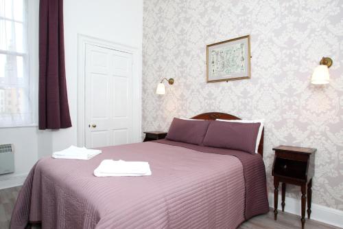 グラスゴーにある52 Charlotte Street , Glasgow green ,City Centerのベッドルーム1室(紫色のベッド1台、タオル2枚付)