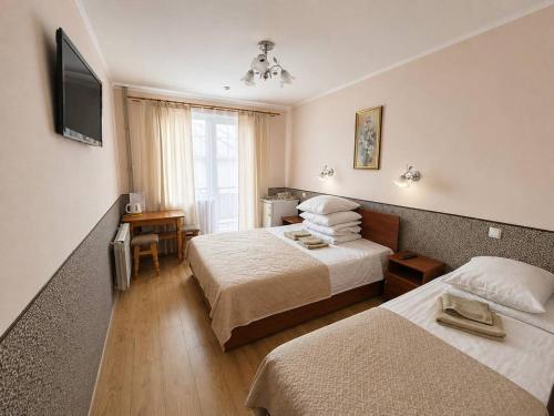 a hotel room with two beds and a television at Hotel Jasmin All Inclusive in Truskavets