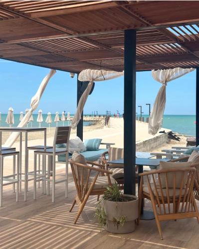 a patio with chairs and tables on the beach at Qerret Boutique Studio Apartment in Golem