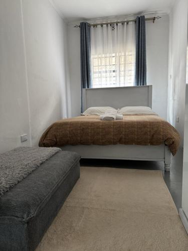 a bedroom with a bed with a window and a rug at Platinum House in Nyeri