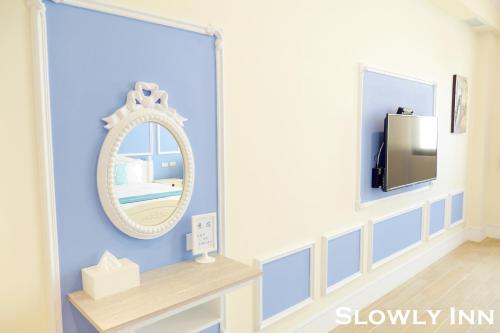 a dressing room with a mirror and a tv at Slowly inn in Hengchun