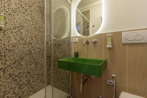 a bathroom with a green sink and a shower at Al centro di Roma in Rome