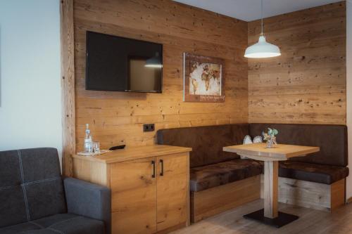 a room with a couch and a table and a television at Alpenstadthotels in Bad Reichenhall