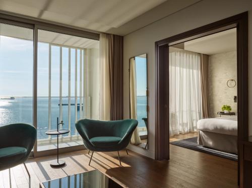 ein Schlafzimmer mit einem Bett, einem Stuhl und einem Fenster in der Unterkunft ON Residence - Small Luxury Hotels of the World in Thessaloniki