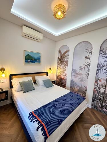 a bedroom with a large bed with a blue and white blanket at NAVU Apartment in Katun