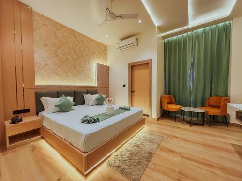 a bedroom with a bed and a table and chairs at Regal Havens in Jorhat