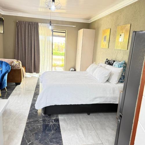 a bedroom with a large bed and a window at Saints boutique lodge in Bloemfontein