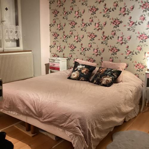 a bedroom with a bed with pink floral wallpaper at Vincenzo le cyclo in Kientzheim
