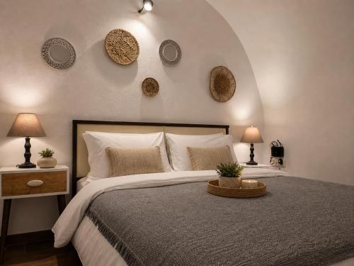 a bedroom with a large bed with plates on the wall at Mare Nostrum Santo in Oia